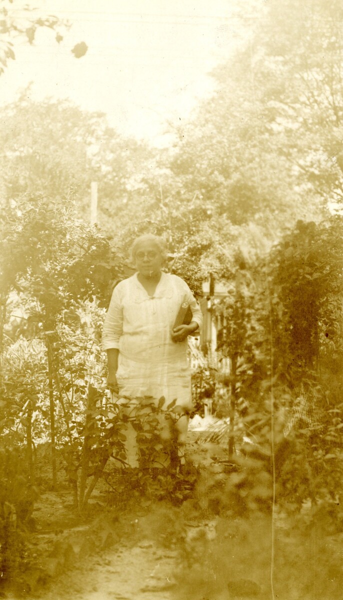 Mrs. Louise Holmes standing in a garden